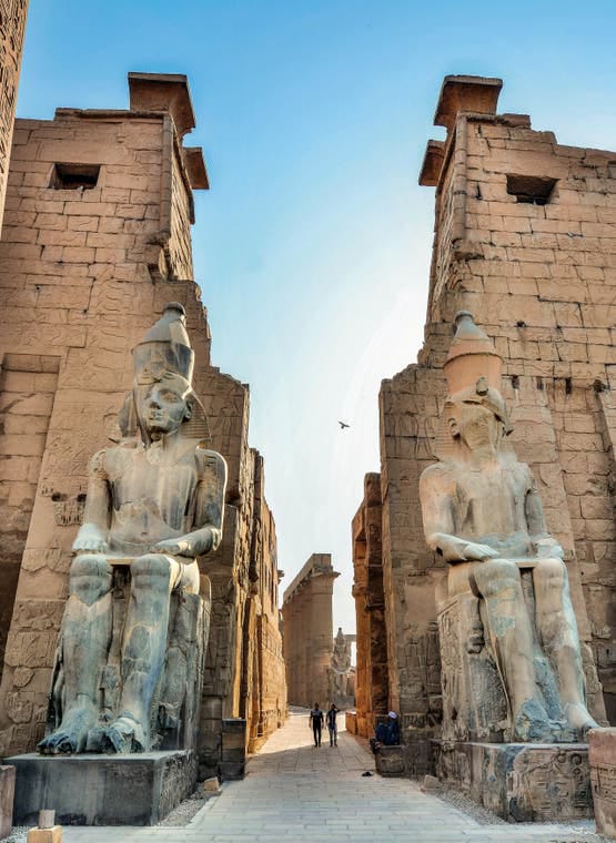 Entrance of Luxor Temple with two large Ramses II statues.